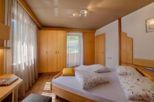 a bedroom with two beds and a window at Pension Brugghof in San Giovanni in Val Aurina