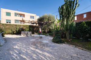 a table and chairs in a yard with a cactus at Luxueux appartement près du port in Sanary-sur-Mer