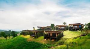 eine Gruppe von Häusern auf einem grünen Hügel in der Unterkunft Chantara Valley Resort in Ban Sap Bon