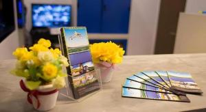 einen Tisch mit zwei Vasen mit Blumen und Broschüren in der Unterkunft Chantara Valley Resort in Ban Sap Bon