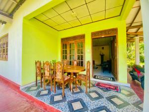 Un comedor con mesa y sillas de madera. en Hiriketiya Lima Homestay, en Dikwella 35 fotos más