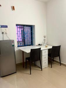 une cuisine avec une table et des chaises et une fenêtre dans l'établissement The Maze House Anjuna!, à Anjuna