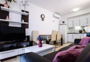 ein Wohnzimmer mit Sofa und Fernseher in der Unterkunft Ganzes Ferienhaus in Pisak mit Privatem Pool in Pisak