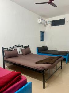 une chambre avec deux lits et un ventilateur de plafond dans l'établissement The Maze House Anjuna!, à Anjuna
