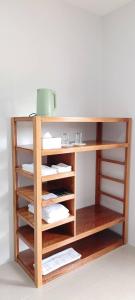 een houten boekenkast met meerdere planken bij Vapanakhaw Ubon in Ubon Ratchathani