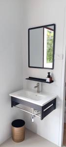 um banheiro com pia branca e espelho em Vapanakhaw Ubon em Ubon Ratchathani