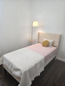 une chambre avec un lit blanc et une lampe dans l'établissement Cozy Getaway 3-Prudential Center, NJPAC, Penn Station, à Kearny