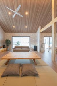 a living room with a ceiling fan and a table at HIGASHIKAWA Villa 瑞月 in Higashikawa