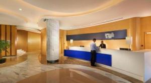 a man standing at a counter in a hotel lobby at Holiday Inn Express Nantong Downtown By IHG in Nantong