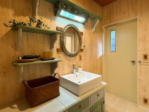 a bathroom with a sink and a mirror at Yufuin Onsen 8A1 Yaeichi in Yufuin