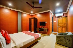 a bedroom with a bed and a ceiling fan at Hotel Eyokar Goa in Candolim