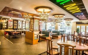 a restaurant with tables and chairs and a bar at Fu Yuan Hotel in Dongguan