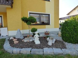 einen Garten mit ausgestopften Tieren vor einem Haus in der Unterkunft Komfortable Ferienwohnung in Gleißenberg mit Garten, Grill und Terrasse in Gleißenberg