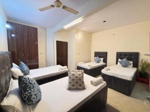 un salon avec deux lits et un ventilateur de plafond dans l'établissement Hotel Divine India Near Expo Center, à Greater Noida