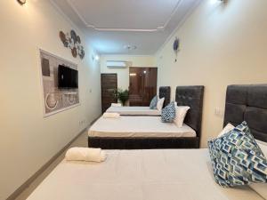 a room with two beds and a flat screen tv at Hotel Divine India Near Expo Center in Greater Noida