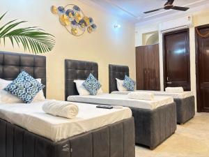 une chambre avec trois lits et un plafond dans l'établissement Hotel Divine India Near Expo Center, à Greater Noida