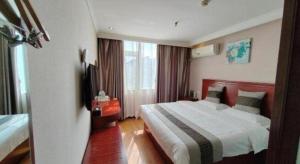 ein Hotelzimmer mit einem Bett und einem Fenster in der Unterkunft GreenTree Inn Luoyang Zhongzheng Street Express Hotel in Luoyang