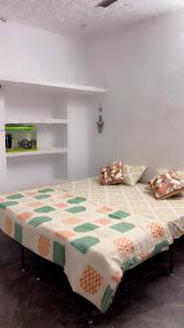 un letto con una trapunta in una stanza di Uddibaba a Shivpuri