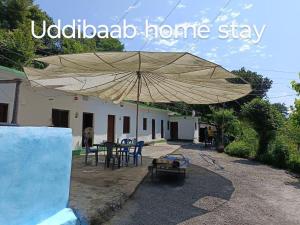 un grande ombrellone appoggiato fuori da una casa di Uddibaba a Shivpuri