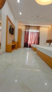 アムリトサルにあるHotel Pilgrim Near Golden Templeのベッド2台とテレビのある広い部屋