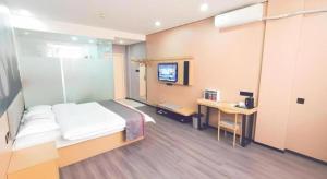 une chambre avec un lit, un bureau et une télévision dans l'établissement Thank Inn Plus Hotel Jiangyin University, à Wuxi 46 autres photos