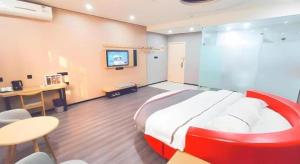 une grande chambre avec un grand lit et un bureau dans l'établissement Thank Inn Plus Hotel Jiangyin University, à Wuxi