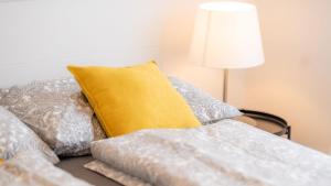 - un lit avec un oreiller et des oreillers jaunes dans l'établissement Ferienhaus Klopeiner See, à Unterburg am Klopeiner See
