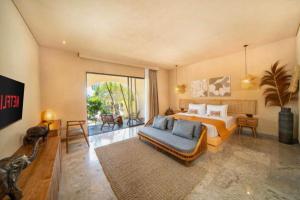 a bedroom with a bed and a couch and a tv at Neona Spacious 4 BR Private Pool Villa ZN364 in Tanah Lot +29 photos