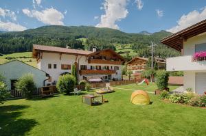 duży dziedziniec z domem i domem w obiekcie Pension Brugghof w mieście San Giovanni in Val Aurina