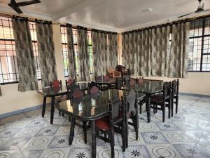 Una sala de conferencias con mesa, sillas y ventanas. en SKT's Wisteria Inn, en Yercaud