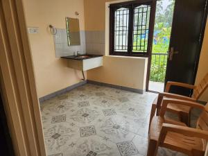 un baño con lavabo y espejo en SKT's Wisteria Inn, en Yercaud 17 fotos más
