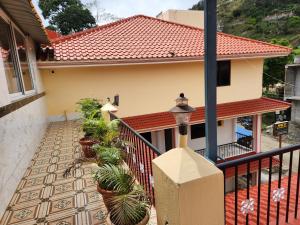 una casa con un balcón con plantas en macetas en SKT's Wisteria Inn, en Yercaud