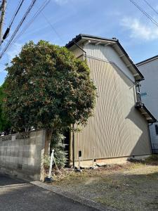 a building with a tree in front of it at Tora House in Nagoya