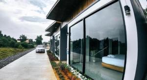 ein Auto, das neben einem Haus mit großen Fenstern parkt in der Unterkunft Seven Days a Week Resort in Ban Khuan Khan