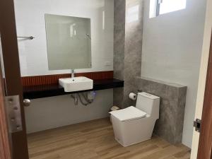 a bathroom with a white toilet and a sink at J&P Hotel Sriracha in Ban Hua Na +20 photos