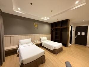 a hotel room with two beds and a table at Bajada Suites in Davao City +11 photos