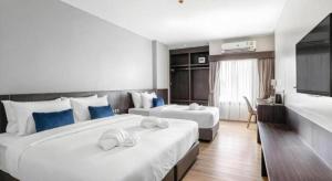 une chambre d'hôtel avec deux grands lits avec des oreillers bleus dans l'établissement XOTEL, à Ban Non Muang 200 autres photos