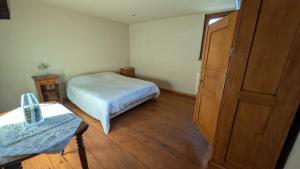 ein kleines Schlafzimmer mit einem Bett und einem Holzboden in der Unterkunft Les Perles du Ried - Gîte 206 in Boofzheim
