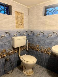 La salle de bains est pourvue de toilettes et d'oiseaux sur le mur. dans l'établissement The Maze House Anjuna!, à Anjuna 26 autres photos