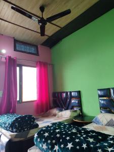Habitación con 2 camas y ventana con ventilador de techo. en Shri Ganesh Home stay, en Ukhimath