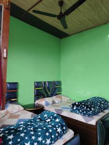 2 camas en una habitación con ventilador de techo en Shri Ganesh Home stay, en Ukhimath