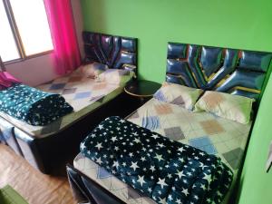 una stanza con due letti con sedie e una finestra di Shri Ganesh Home stay a Ukhimath Altre 18 foto