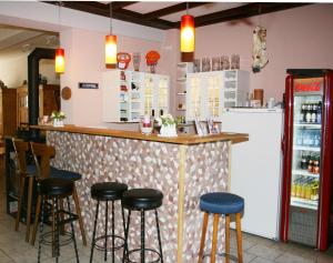 a restaurant with a bar with stools and a refrigerator at Pension bei Schinderhannes und Julchen in Boppard