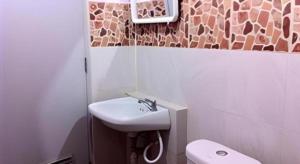 ein Badezimmer mit Waschbecken und Toilette in der Unterkunft Roong Arun Resort in Pumriang