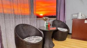 GreenTree Inn Shanghai Sheshan national tourist resort Express Hotel في Fenghuangshan: كرسيين وطاولة في غرفة مع طاولة