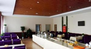 a dining room with purple chairs and a long table at GreenTree Inn Langfang GuAn County Xinyuan Street Express Hotel in Gu'an