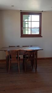 einen Holztisch mit zwei Stühlen und einem Fenster in der Unterkunft Les Perles du Ried - Gîte 207 in Boofzheim