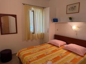 a bedroom with a bed with two pink pillows at Apartments Magdalena - Bungalow with terrace A1 in Bol