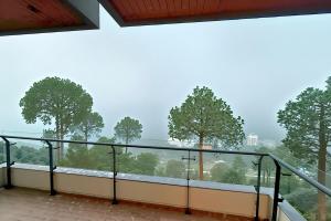 Elle comprend un balcon offrant une vue sur les arbres. dans l'établissement Luxury Studio at Monal Murree Balcony with Private Parking, à Murree