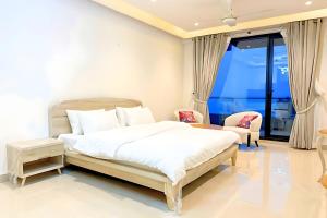 une chambre avec un grand lit blanc et une chaise dans l'établissement Luxury Studio at Monal Murree Balcony with Private Parking, à Murree 9 autres photos